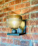 Wall-mounted outdoor light fixture on a brick wall