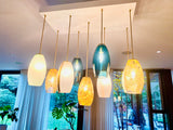 Modern pendant lights hanging from the ceiling in a room with large windows.