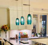 Modern kitchen with teal pendant lights and decorative elements.