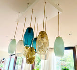 Set of hanging pendant lights with glass shades in a modern interior setting.