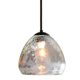 An amazing crackled clear glass pendant fully lit, creating warm reflections.