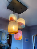 Modern chandelier with colorful glass pendants in a room setting.