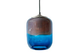Glass pendant light with a gradient design transitioning from blue to amber on a white background, turned off