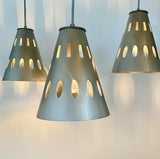 Three modern perforated steel pendant lights with a brushed steel finish, featuring a geometric design and a color cord selection.