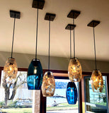 6 paired hand-blown glass lights hanging from the ceiling.