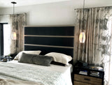 A bedroom scene light by two hand-blown glass pendants with opaline coloring and silver-lead details.