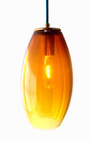 A hand-blown glass pendant with red to yellow topaz coloring, fully illuminated and glowing on a white background
