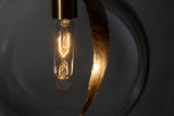 A lightbulb inside of a sphere glass pendant light with a gold leaf detailing, hanging from a metal chain in low lighting with a dark grey background