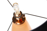 A lightbulb in the socket of a SERAFINA rose-glass lamp with copper metal detailing.
