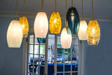 9 ELECTTRA pendants fully on, illuminating the room with whites, gold-leaf patterns, and blues.
