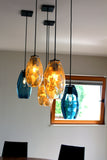 A dinning room scene with hanging pendants as center pieces.