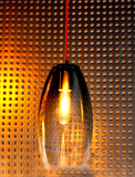 Hand-blown, mold-formed glass pendant with a grey fade color with a metal patterned background