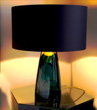The blue glass amd Charcoal top varient of the SERAFINA lamp collection illuminating a room with warm light.