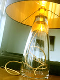 A living room scene with a gold interior glass lamp illumination the room