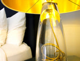 Gold light refecting on the clear glass of the SERAFINA lamp